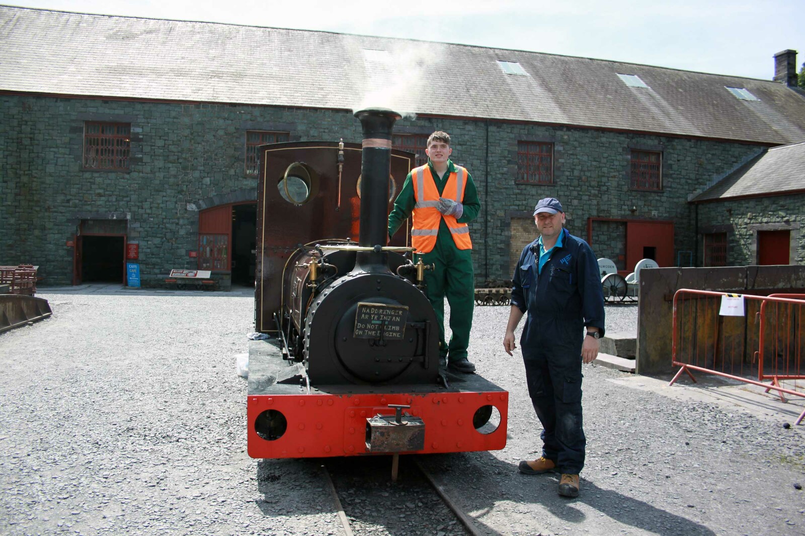 Two men standing by a steam train